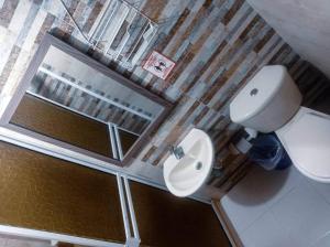 a bathroom with a toilet and a sink and a mirror at Sweetroom Miss Gloria in Estación El Salto