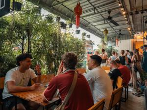 a group of people sitting at a table in a restaurant at Stamps Backpackers in Chiang Mai