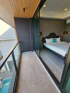 ein Schlafzimmer mit einem Bett und einigen Glasfenstern in der Unterkunft Hotel Le Naga in Sakon Nakhon