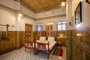 a bathroom with a bed and a shower at Chettinadu Mansion – An Authentic Heritage Palace in Kānādukāttān