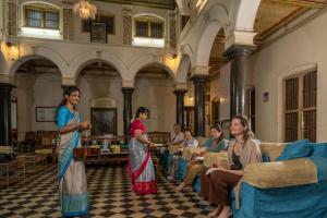 a group of women standing in a room at Chettinadu Mansion – An Authentic Heritage Palace in Kānādukāttān