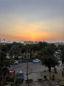 a sunset over a parking lot with cars parked at Peaceful Stay at Vrindavan in Vrindāvan +5 photos