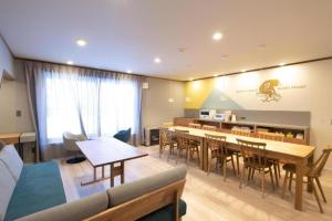 a living room with a couch and a table and chairs at B Cycleトリプルルーム in Biei