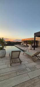 a patio with lounge chairs and a swimming pool at Amplio Estudio con Balcon Tuk 004 in Tulum