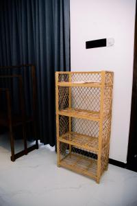 a wooden book shelf sitting next to a black curtain at Paddy Breeze Villa in Batigama