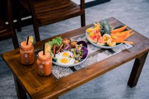a wooden table with two plates of food on it at Paddy Breeze Villa in Batigama