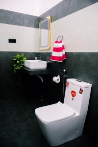 a bathroom with a white toilet and a sink at Paddy Breeze Villa in Batigama