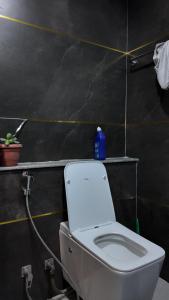 a bathroom with a toilet with a blue bottle on it at Kings Palace in Kathmandu