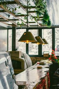 a dining room with a long table and pendant lights at Duet hostel in Karakol