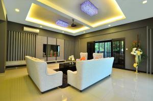 a living room with white chairs and a table at Violet Luxury Service Villa in Batu Ferringhi