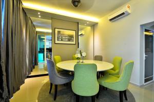 a dining room with a table and green chairs at Violet Luxury Service Villa in Batu Ferringhi