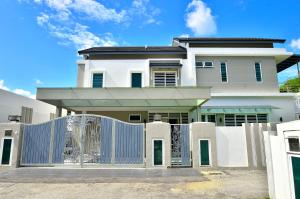 Uma casa branca com um portão à frente. em Violet Luxury Service Villa em Batu Ferringhi
