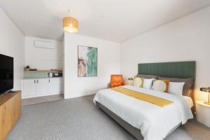 a bedroom with a large bed and a flat screen tv at The Avalon in Mount Gambier