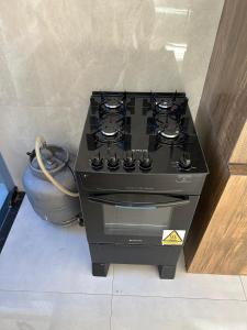 a stove in a kitchen next to a pot at Casa com 3 quartos aconchegante in Anápolis