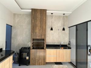 a kitchen with wooden cabinets and a stove at Casa com 3 quartos aconchegante in Anápolis