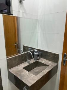 a bathroom with a sink and a mirror at Casa com 3 quartos aconchegante in Anápolis +34 photos