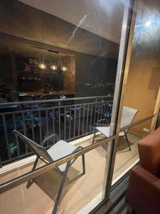 a balcony with two chairs and a view of a city at Comodidad, sol y descanso total in Melgar
