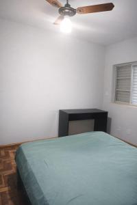 a bedroom with a bed and a ceiling fan at Quarto em Barretos, simples com paz e harmonia in Barretos