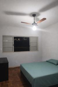 a bedroom with two beds and a ceiling fan at Quarto em Barretos, simples com paz e harmonia in Barretos