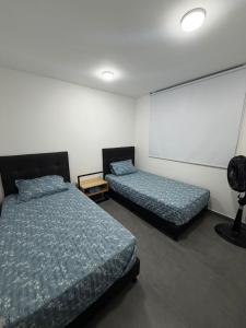 a bedroom with two beds and a projector screen at Comodidad, sol y descanso total in Melgar +8 photos