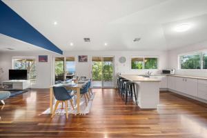 a kitchen with white cabinets and a table and chairs at Hinterland Tranquil Escape with Beautiful Views in Ninderry
