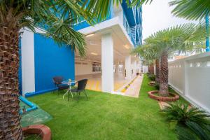 a hallway with palm trees and a table and chairs at DF Hotel Pattaya in Pattaya South
