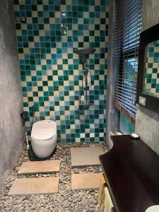 a bathroom with a toilet and a tiled floor at emoi valley bavi in Ba Vì