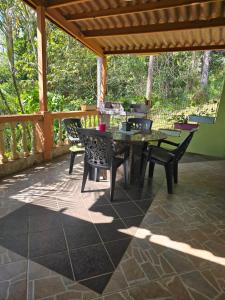 a patio with a table and chairs on it at El Nido Cerro Azul in Cerro Azul
