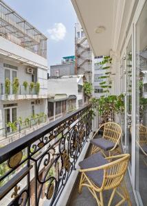 a balcony with two chairs sitting on a railing at V Living - Airport Stopover with Free Laundry in Ho Chi Minh City
