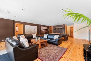 a living room with leather couches and a coffee table at Fiddler Lake Resort - Deer 69 in Mille-Isles