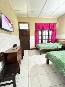 a room with two beds and a tv in it at Tilamsari Hotel in Wonosari