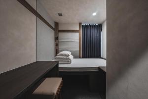 a small room with a bed and a window at GOYOO INN & cabins in Seoul