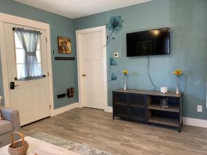 a living room with a tv on a blue wall at Poppy's Place in Chanute