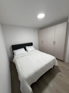 a bedroom with a large white bed with white sheets at Granite Grove Suite in Winnipeg