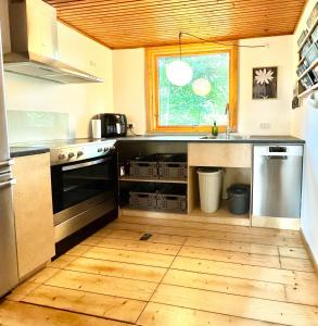 a kitchen with a sink and a stove at Architectural Cottage On 7000 Sqm Nature Plot in Hadsund