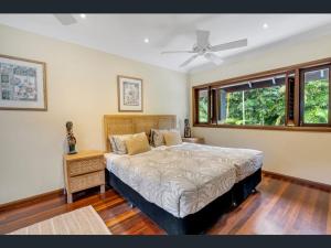 a bedroom with a bed and a ceiling fan at Solander Beachfront with private beach access & pool in Port Douglas +23 photos