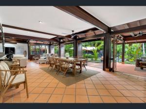 a large living room with a table and chairs at Solander Beachfront with private beach access & pool in Port Douglas