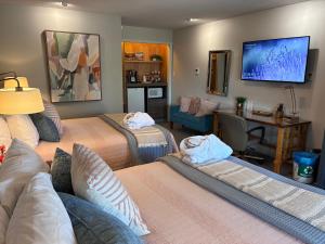 a room with two beds and a tv on the wall at Discovery Inn in Friday Harbor