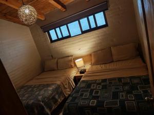 a small room with two beds and a window at Cabañas Quinta de Cuevas in Mazamitla