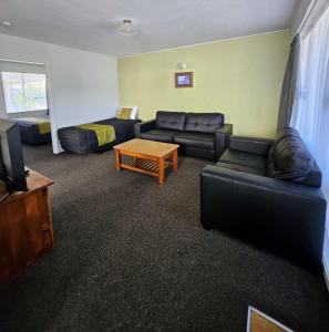 a living room with a couch and a table at Scenicland Motels in Greymouth