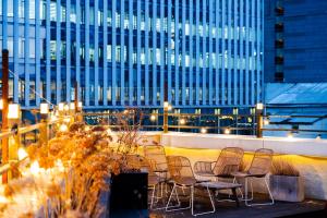 a group of chairs sitting on a balcony with a building at MONTHLIV Euljiro Hotel Stay in Seoul