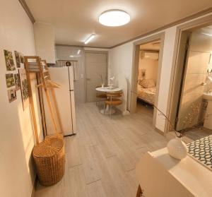 a room with a refrigerator and a table and a bedroom at 건대역5분 성수 감성숙소 5 min walk to Konkok Univ Station # 6-Minute Walk to Airport Limousine # Seongsu Cafe Street Walking Tour Hotspots & Pop-up Stores #Seoul Forest # Thukseom Han River Park #KSPO # COEX #Gangnam in Seoul