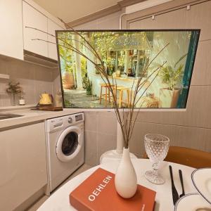 a kitchen with a washing machine and a vase on a table at 건대역5분 성수 감성숙소 5 min walk to Konkok Univ Station # 6-Minute Walk to Airport Limousine # Seongsu Cafe Street Walking Tour Hotspots & Pop-up Stores #Seoul Forest # Thukseom Han River Park #KSPO # COEX #Gangnam in Seoul