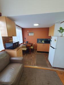 a kitchen with a couch and a refrigerator and a table at Sunbury Central in Sunbury