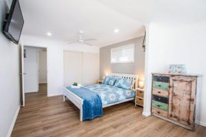a bedroom with a bed and a dresser at Canny Breeze in Agnes Water