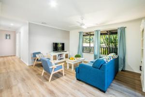 a living room with a blue couch and chairs at Canny Breeze in Agnes Water