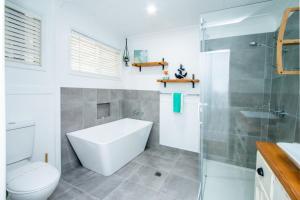 a bathroom with a tub and a toilet and a shower at Canny Breeze in Agnes Water +15 photos