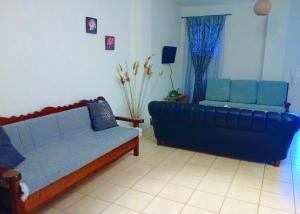 a living room with two couches and a blue couch at Στης Χαράς in Porto Heli