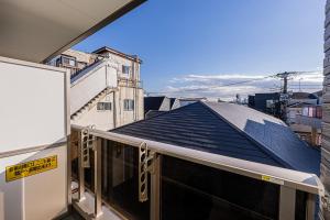 ein Balkon mit Blick auf ein blaues Dach in der Unterkunft Mi-Hotel Ikebukuro 池袋 in Tokio