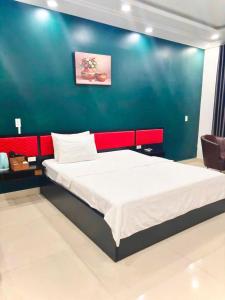 a bedroom with a large bed with a blue wall at Hưng Phú Hotel HCM in Ho Chi Minh City